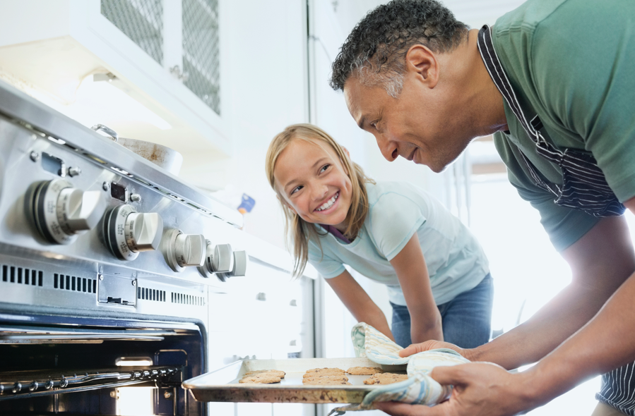 Man and child taking cookies out of oven | BCBS of Tennessee