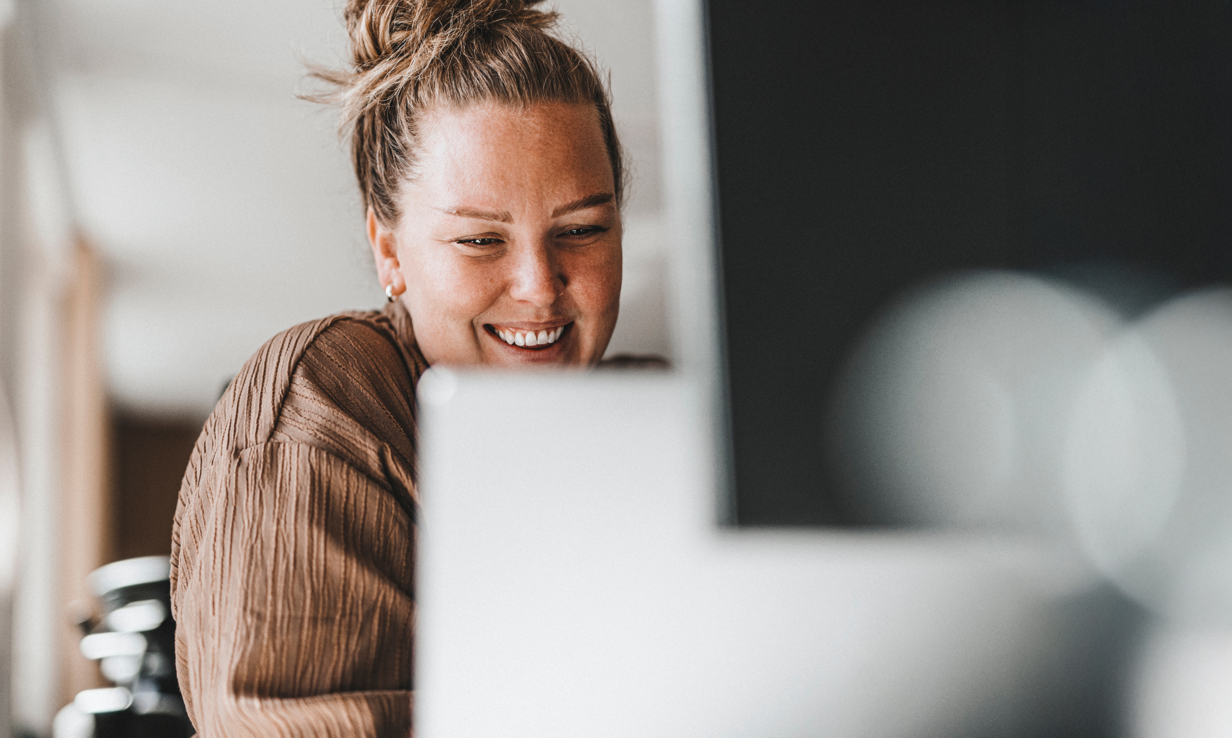 Person sitting at desk working on a laptop.
