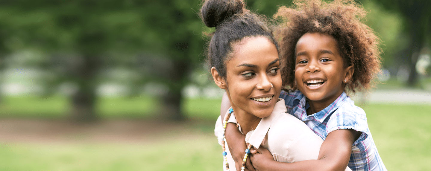 Woman with daughter smiling on her back